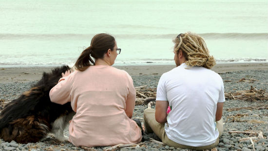 Caleb and Gabe on a beach with their dog